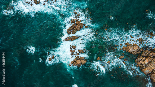  Island coastline with powerful waves breaks on the rocks  early in the morning. Aerial view over the mediterane ocean water at the steep cliffs. Drone shot Italy
