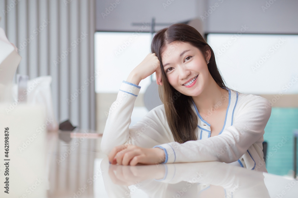 Beautiful adult young age Asian professional woman with long hair in white shirt looks at the camera her smiling happily while she sits on chair in workplace office.
Beautiful adult young age Asian professional woman with long hair in white shirt looks at the camera her smiling happily while she sits on chair in workplace office.