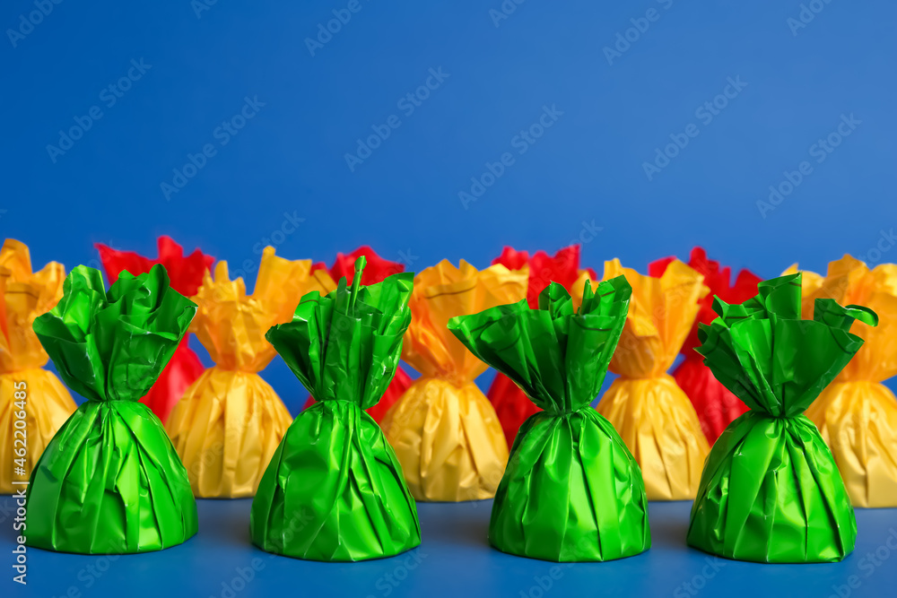 Candies in colorful wrappers on blue background