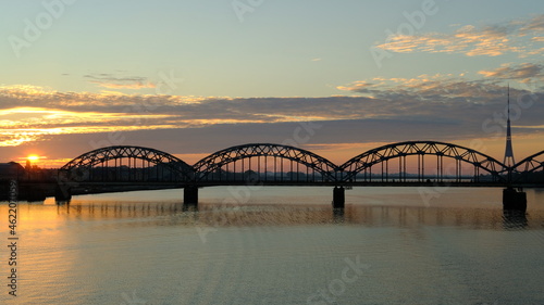 Photo of a railway bridge with a TV tower in Riga in autumn at dawn.
