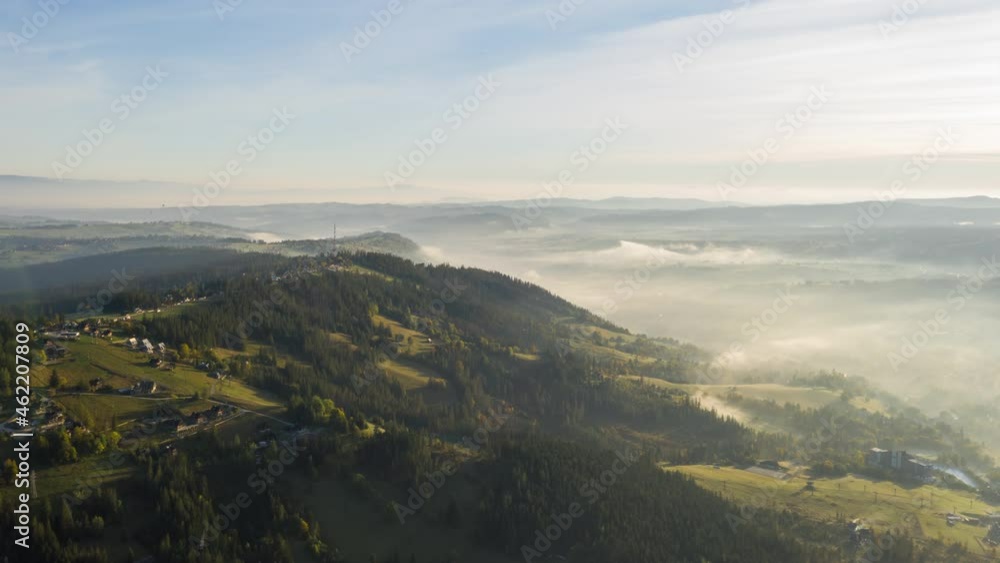 Aerial timelapse hyperlapse flight over amazing hilly landscape lit with warm morning sunlight. Drone shot radio station tower on hill in haze sunrise light. Highlands, clouds of fog moving fast Aerial timelapse hyperlapse flight over amazing hilly landscape lit with warm morning sunlight. Drone shot radio station tower on hill in haze sunrise light. Highlands, clouds of fog moving fast