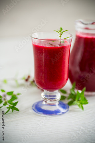 freshly squeezed thick natural juice with pulp from ripe red viburnum in a decanter