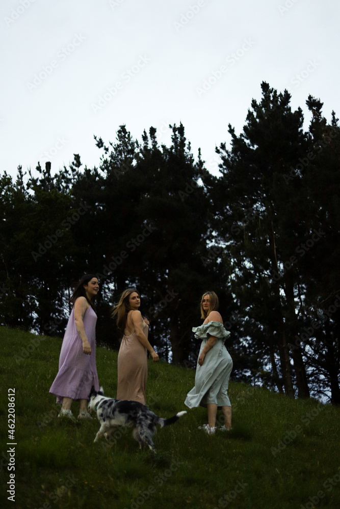 Obraz premium girlfriends smiling in nature in colorful dresses during spring