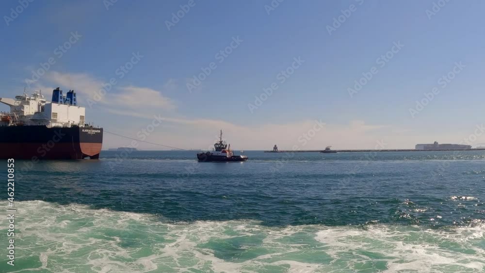 Ocean view from a boat in the harbor looking out to sea with huge freight ships waiting to be loaded Ocean view from a boat in the harbor looking out to sea with huge freight ships waiting to be loaded