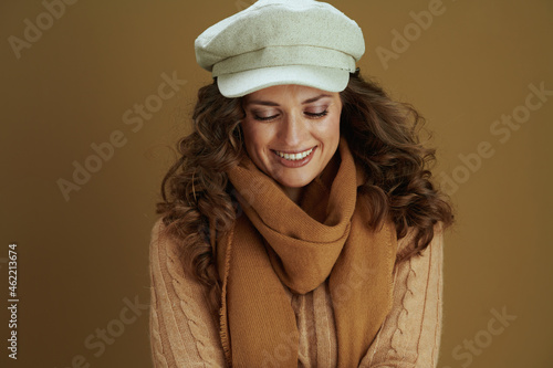 happy elegant woman in sweater against brown background