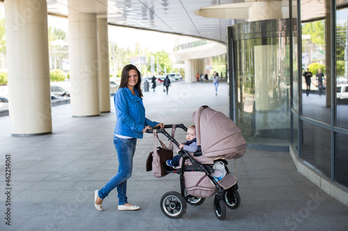 Young mother walking and pushing a stroller