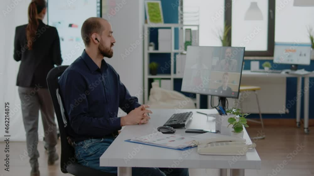 Businessman using video call on computer for meeting with colleagues. Adult talking to workmates on online conference for remote project planning. Man working on company management Businessman using video call on computer for meeting with colleagues. Adult talking to workmates on online conference for remote project planning. Man working on company management