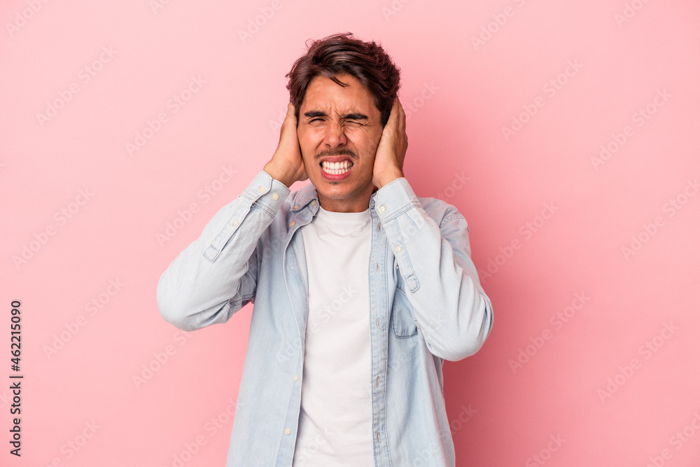 Young mixed race man isolated on white background covering ears with hands. Young mixed race man isolated on white background covering ears with hands.