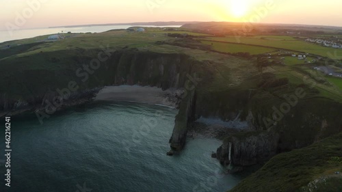 An aerial shot revealing the Pembrokeshire coast near Manorbier beach with Church door cove at sunset on a calm summer day photo