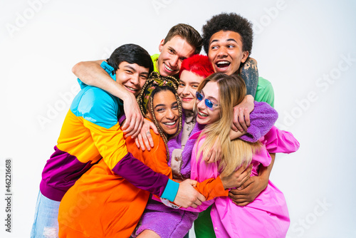 Happy young male and female friends embracing each other on against white background