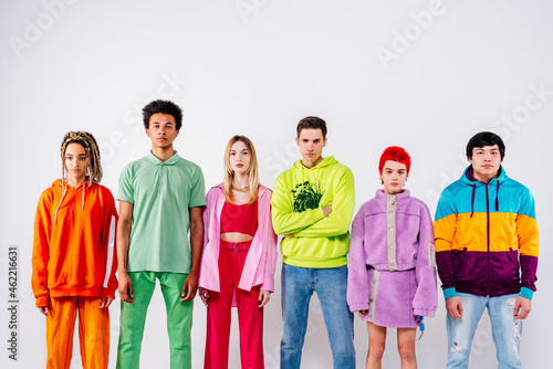 Stylish men and women in colorful clothes looking at camera against white background