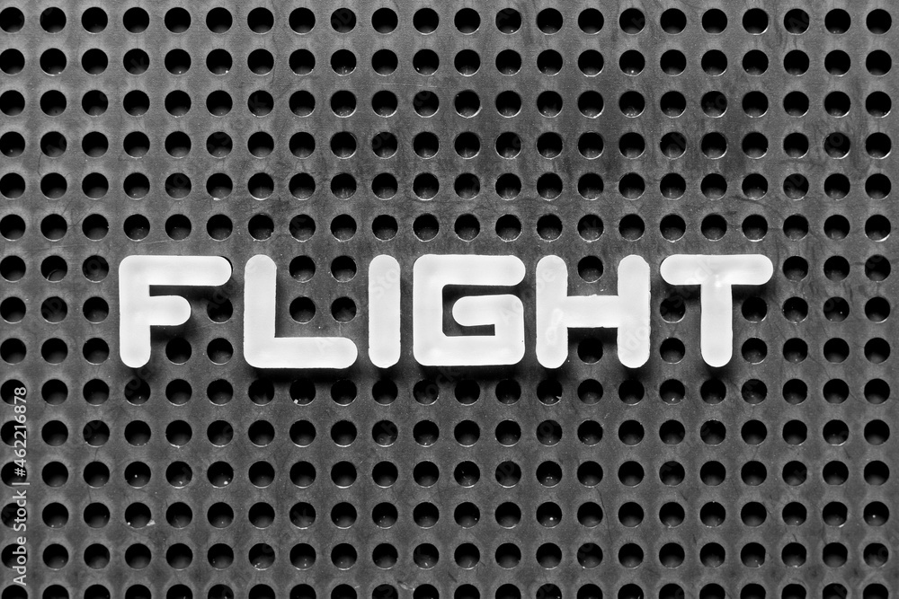 White alphabet letter in word flight on black pegboard background White alphabet letter in word flight on black pegboard background