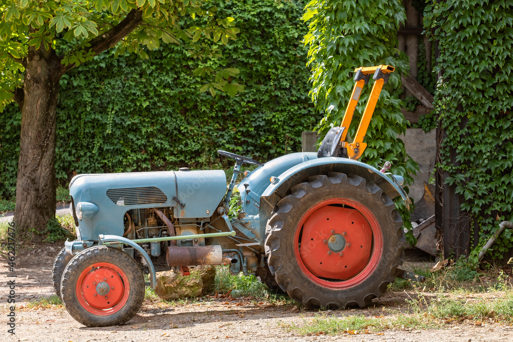 An old blue old tractor still in use on a farm An old blue old tractor still in use on a farm