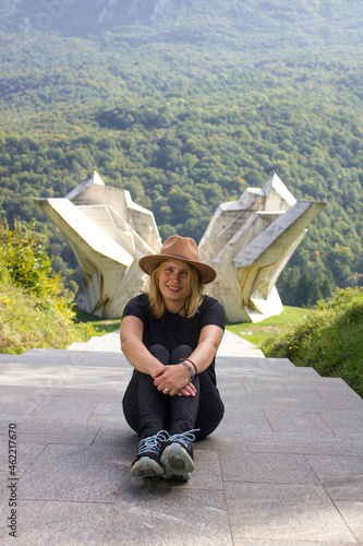 girl sitting in font of memorial on world war in Sutjeska National Park, Bosnia and Herzegovina, Europe