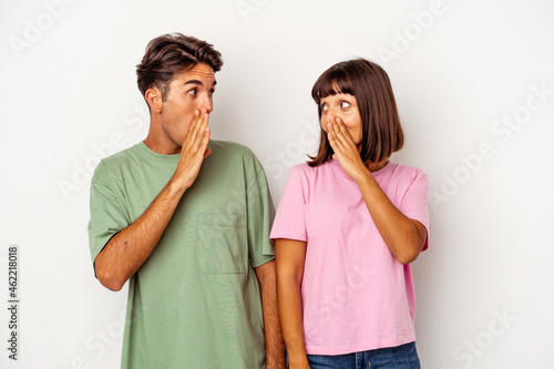 Young mixed race couple isolated on white background being shocked because of something she has seen.