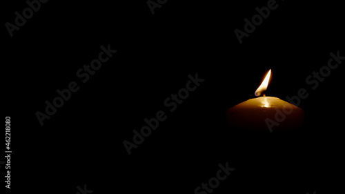 Close up Burning candle isolated on black background right side of picture