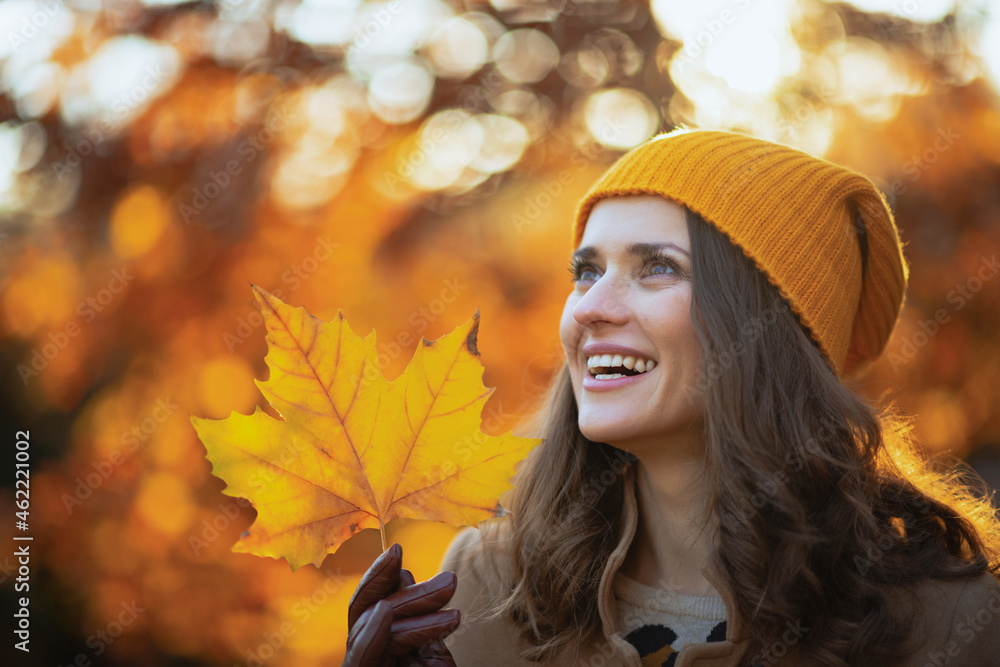 happy woman in brown coat and yellow hat - obrazy, fototapety, plakaty 