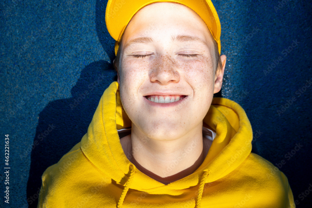 Boy in yellow sweatshirt smiling with eyes closed Boy in yellow sweatshirt smiling with eyes closed