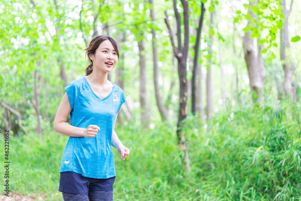 自然の中でランニングをする若い女性