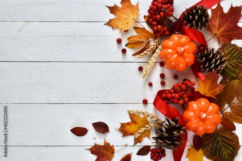 Autumn decor from pumpkins  fir cones and leaves on a white wood background. Concept of Thanksgiving day or Halloween. Flat lay autumn composition with copy space.