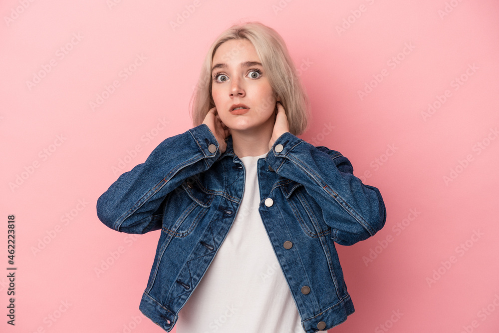 Young caucasian woman isolated on pink background touching back of head, thinking and making a choice. Young caucasian woman isolated on pink background touching back of head, thinking and making a choice.