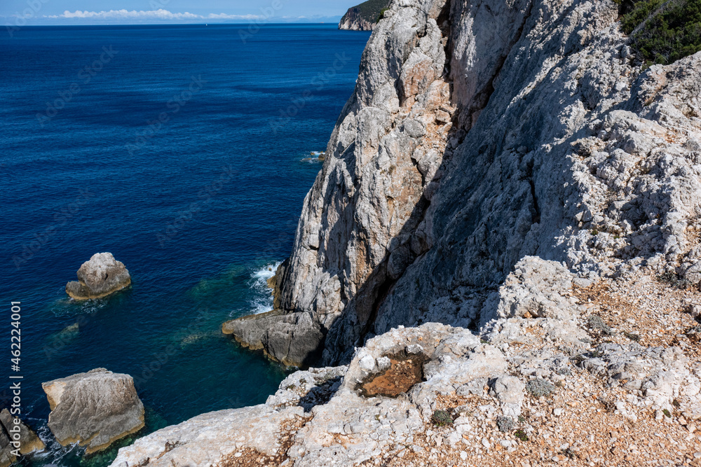 Rocky steep cliff look down on blue vivid Ionian sea stormy waves hitting shore. Summer nature in Lefkada island, Greece