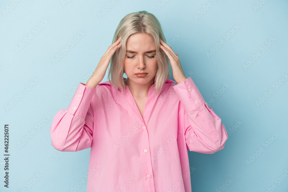 Young caucasian woman isolated on blue background touching temples and having headache. Young caucasian woman isolated on blue background touching temples and having headache.