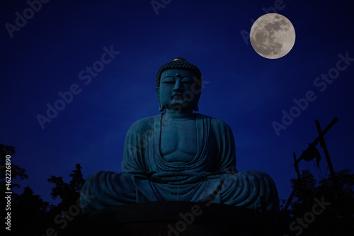 Full moon above the The Great Buddha (Daibutsu) on the grounds of from Wat Phra That Doi Phra Chan in Lampang, the north of thailand. photo