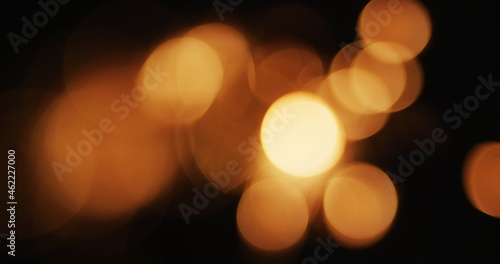 Multiple warm orange lights flickering on black background © vectorfusionart