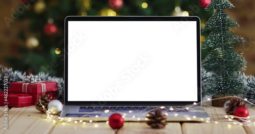 Laptop with copy space on screen, with christmas decorations and tree