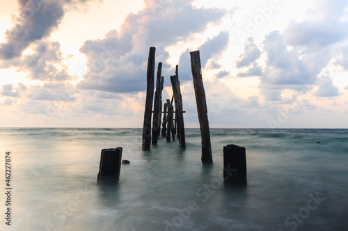 Old wooden bridge abandoned pier stumps at Thungsang bay in Chomphon province Thailand, Tropical beach seaside, White Balance effect photo