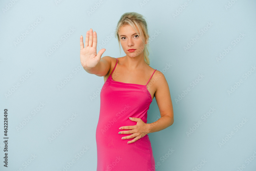 Young Russian woman pregnant isolated on blue background standing with outstretched hand showing stop sign, preventing you. Young Russian woman pregnant isolated on blue background standing with outstretched hand showing stop sign, preventing you.