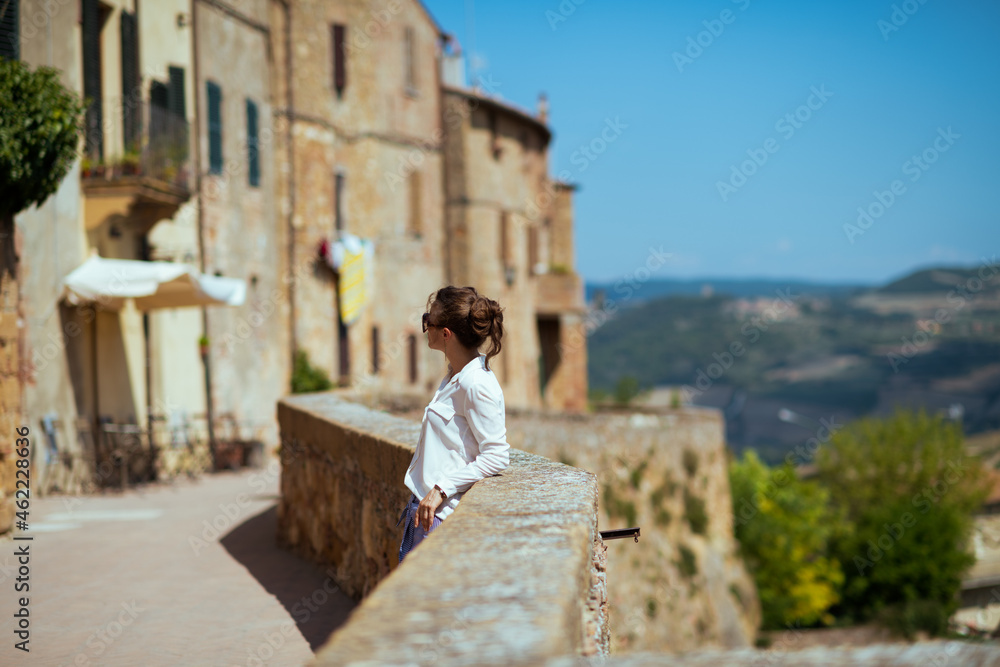 Seen from behind traveller woman in Tuscany, Italy sightseeing
