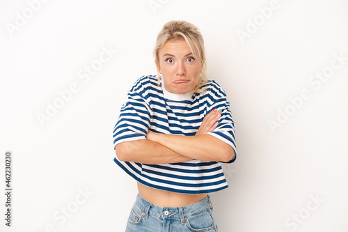 Young Russian woman isolated on white background shrugs shoulders and open eyes confused.
