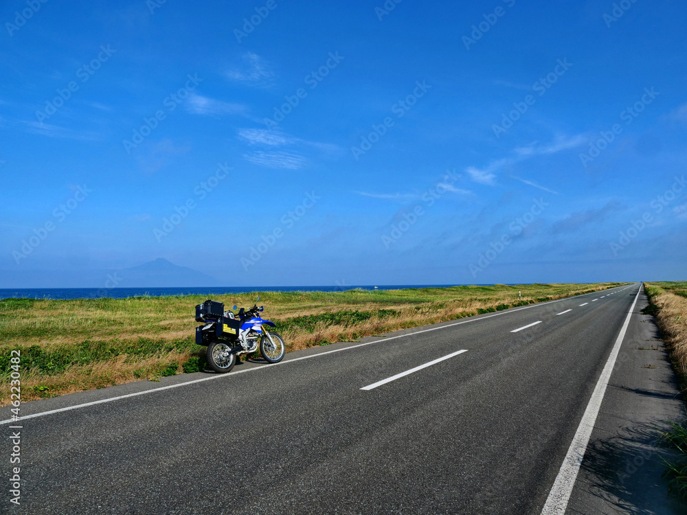 青空と地平線へ延々と遠くに続く道とバイク 青空と地平線へ延々と遠くに続く道とバイク