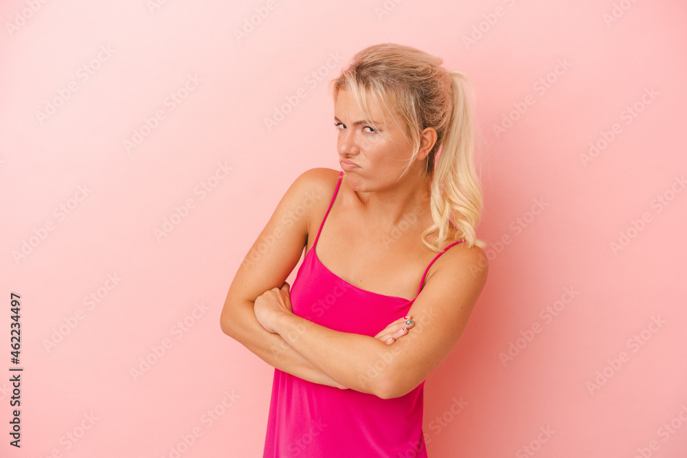 Young Russian woman isolated on pink background suspicious, uncertain, examining you. Young Russian woman isolated on pink background suspicious, uncertain, examining you.