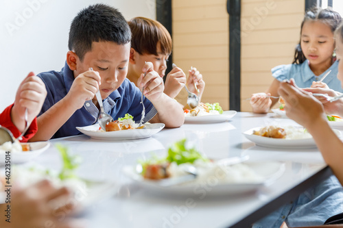 Group Of Children Eating Lunch In School photo