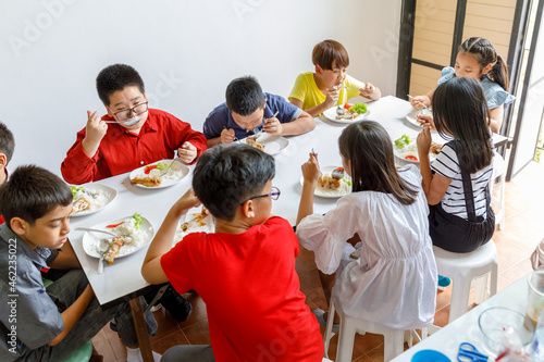Group Of Children Eating Lunch In School photo