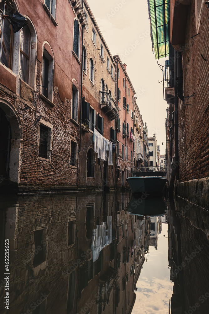 a narrow canal with a boat in charming Venice