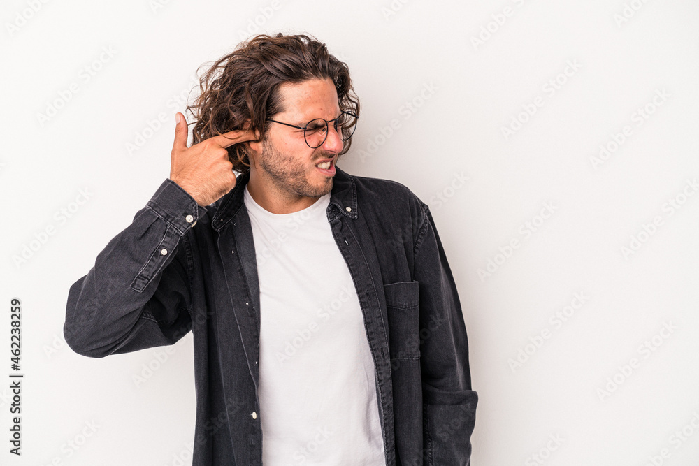 Young caucasian man isolated on white background covering ears with hands. Young caucasian man isolated on white background covering ears with hands.