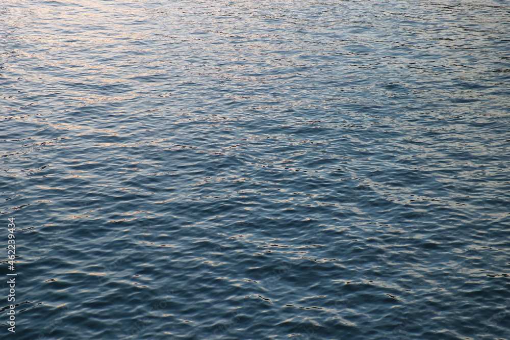 Calm ripple on water surface. River, lake, pond, sea pure blue water. Warm evening light on the water surface. Calm ripple on water surface. River, lake, pond, sea pure blue water. Warm evening light on the water surface.