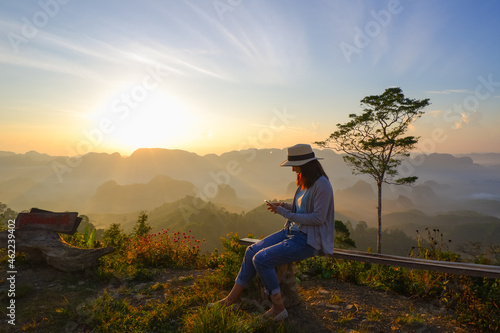 young asia woman feeling happy wearing hat resting on tropical mountain at Doi Ta Pang (khao thalu) travel in chumphon thailand
