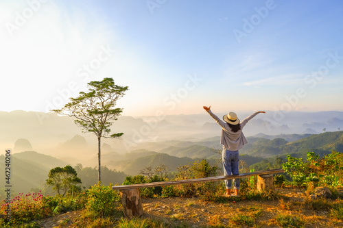 young asia woman feeling happy wearing hat resting on tropical mountain at Doi Ta Pang (khao thalu) travel in chumphon thailand