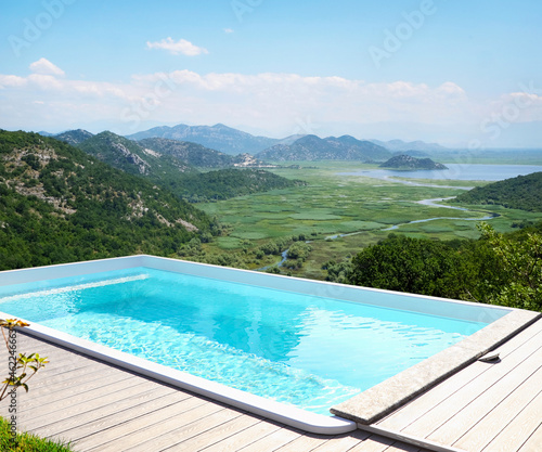 Outdoor swimming pool at luxury resort and beautiful view of mountains on sunny day