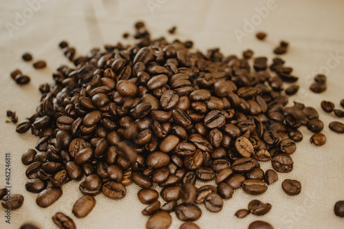 Close-up image of amount coffee bean in a background beige isolated.