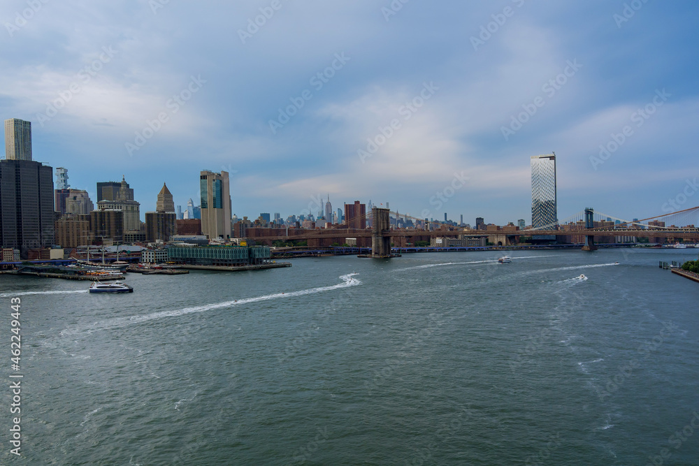 Brooklyn Bridge and Manhattan Bridge with Manhattan New York City skyscrapers city skyline over Hudson River.