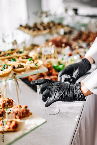 woman hands of a waiter prepare food for a buffet table in a restaurant