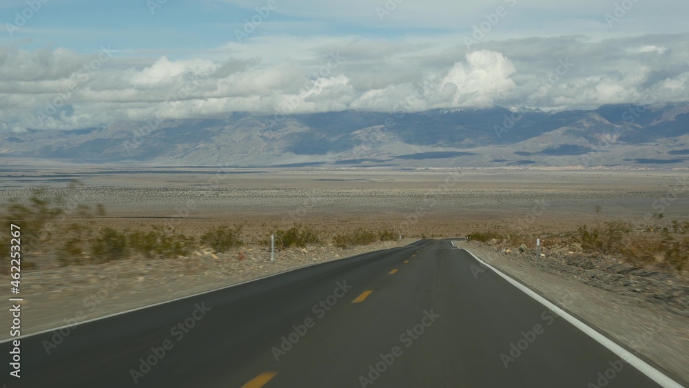 Road trip to Death Valley, driving auto in California, USA. Hitchhiking traveling in America. Highway, mountains and dry desert, arid climate wilderness. Passenger POV from car. Journey to Nevada.