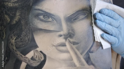 Close-up shooting of female back during tattoo making
