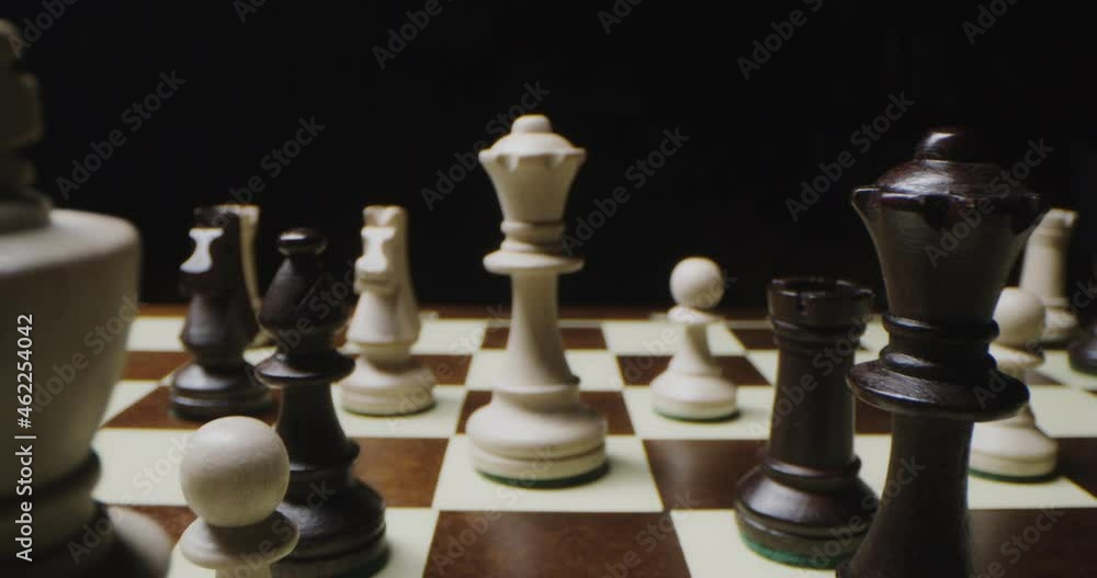 Black and white chess pieces stand on the chessboard in a chaotic manner Black and white chess pieces stand on the chessboard in a chaotic manner